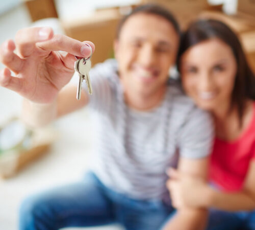 Hand of young man showing keys from new flat